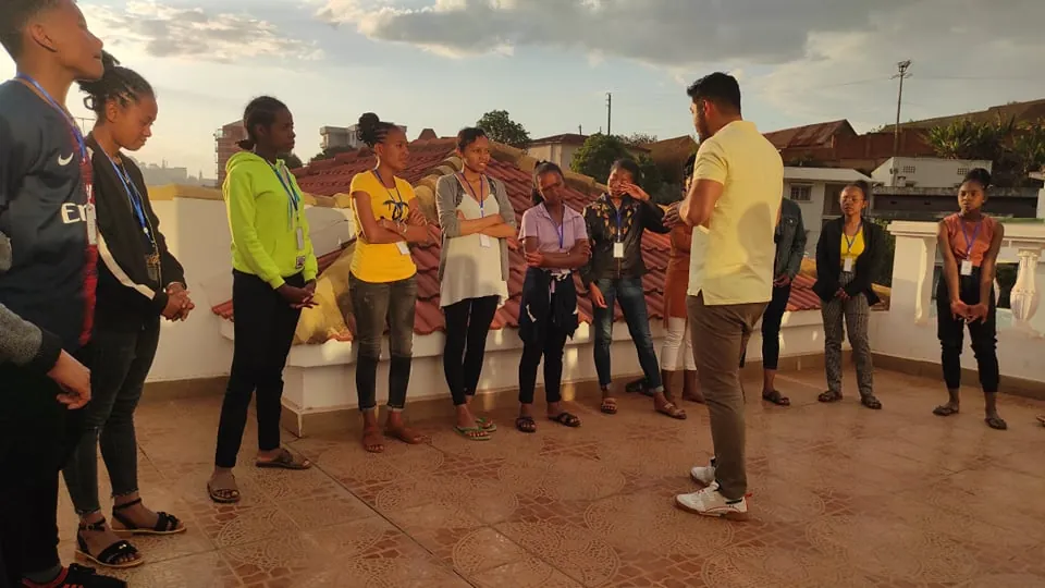 Le groupe réuni en cercle sur une terrasse, au coucher du soleil